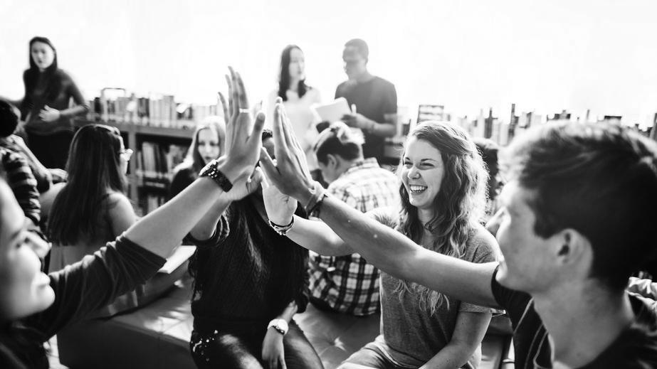 Group of youngsters slaping hands in greeting